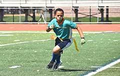 一个小男孩在玩国旗橄榄球.